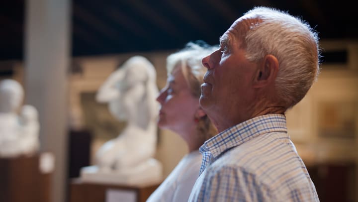 A senior couple in a museum appreciating a work of art.