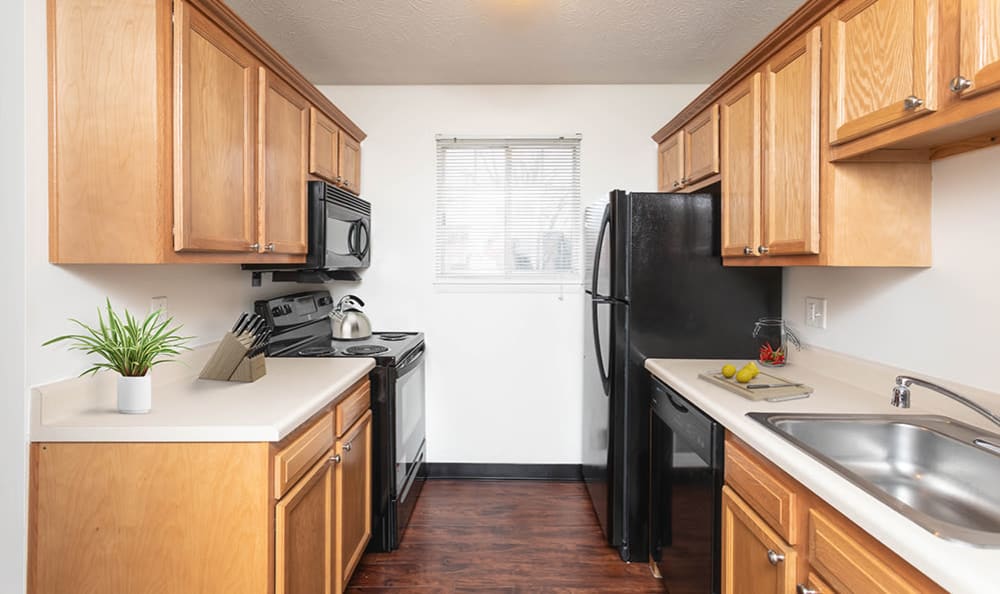 Kitchen with black appliances at Waverlywood Apartments & Townhomes in Webster, New York