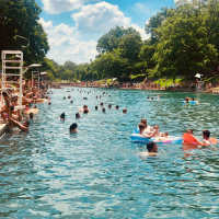 Resort-style pool with people swimming at Sutton in Austin, Texas
