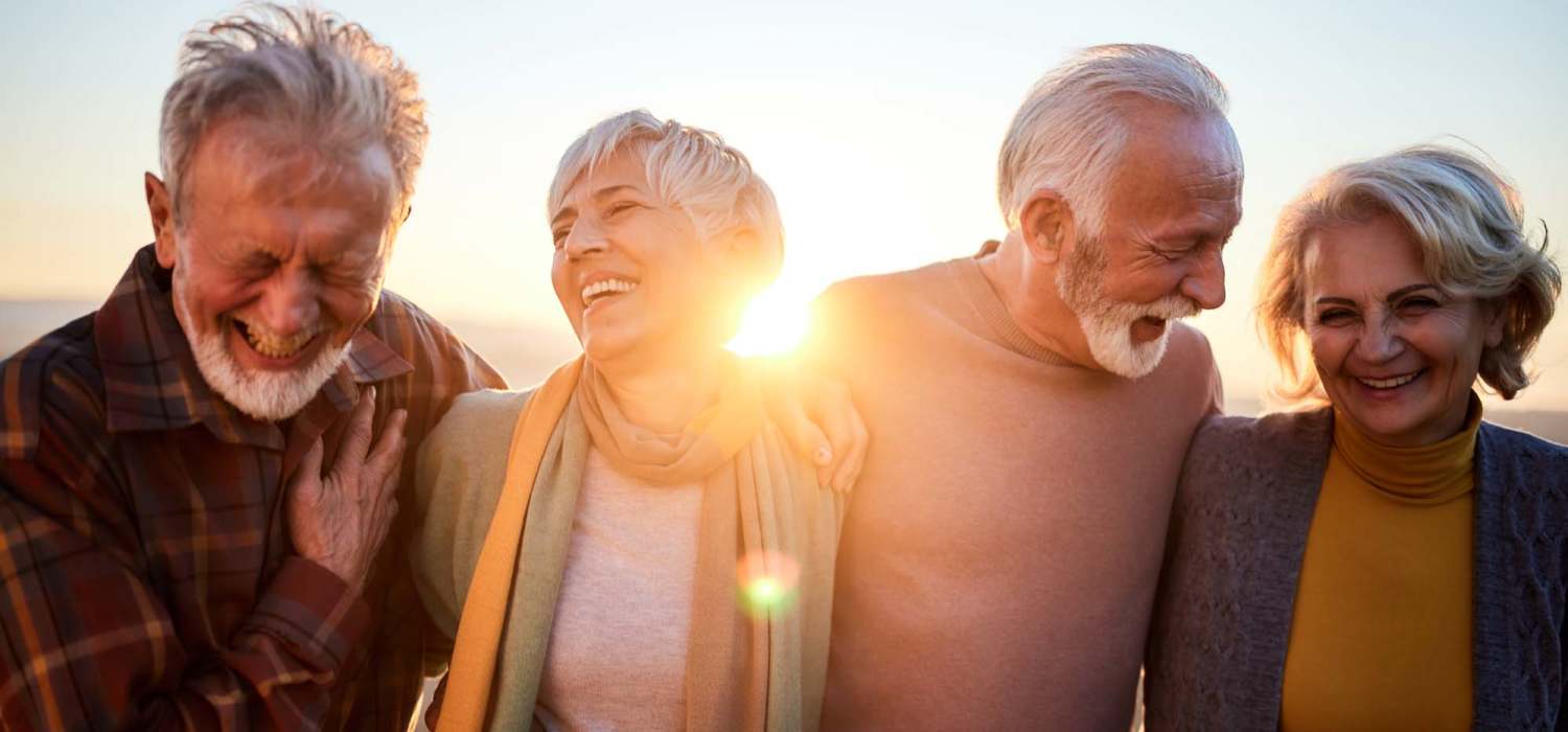 Group of four laughing residents at Grande Oak Apartments in Williamsburg, Virginia