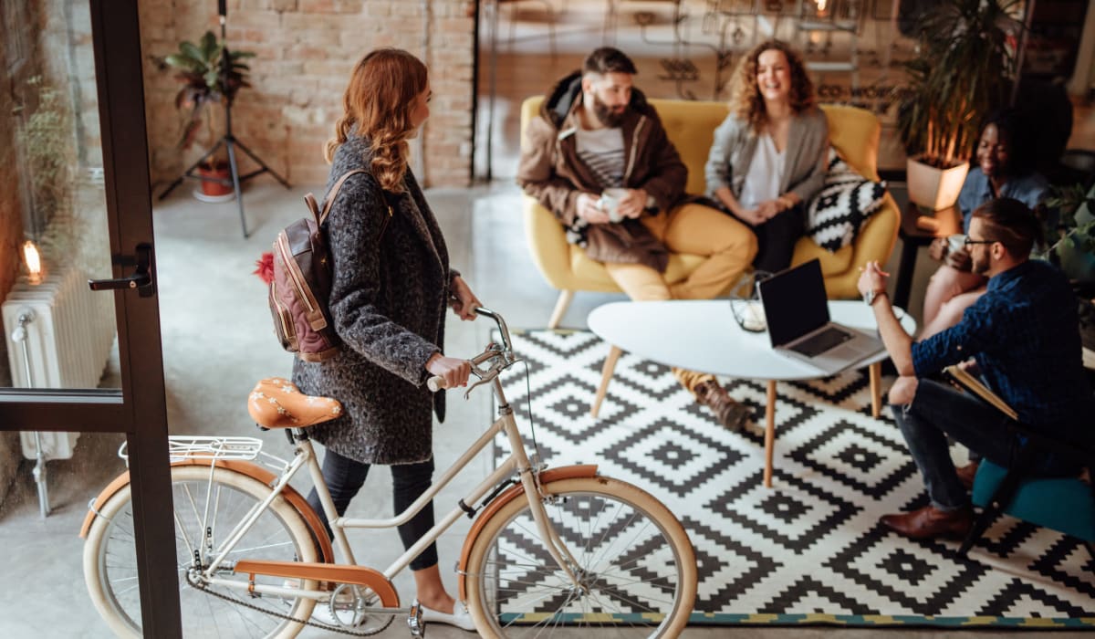 A woman with a bicycle meets team mates in a coffee shop Decron Properties, Los Angeles, California