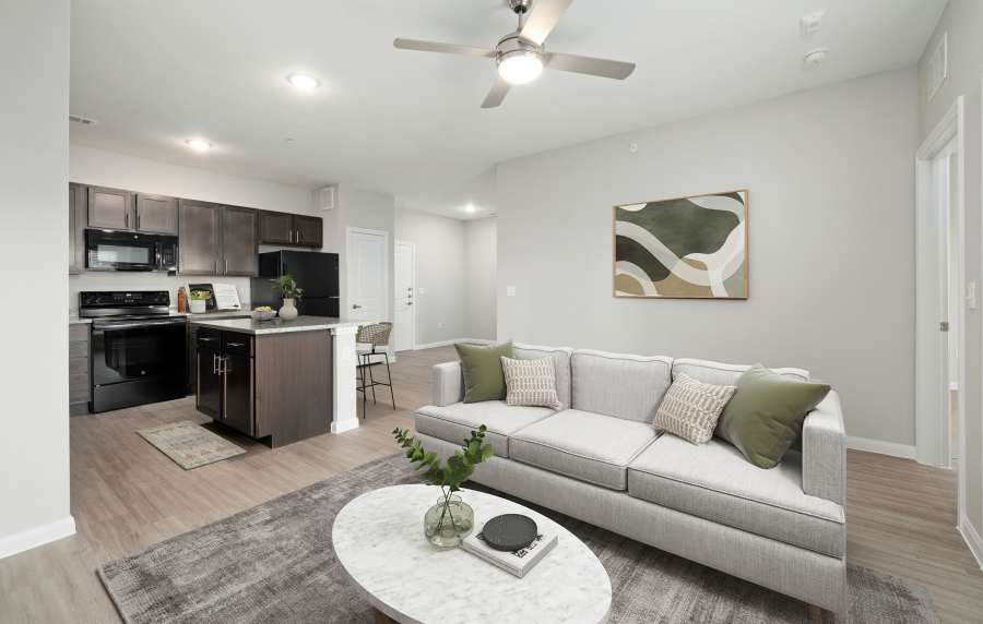 Spacious living room with kitchen in the background at The Janson in Del Valle, Texas