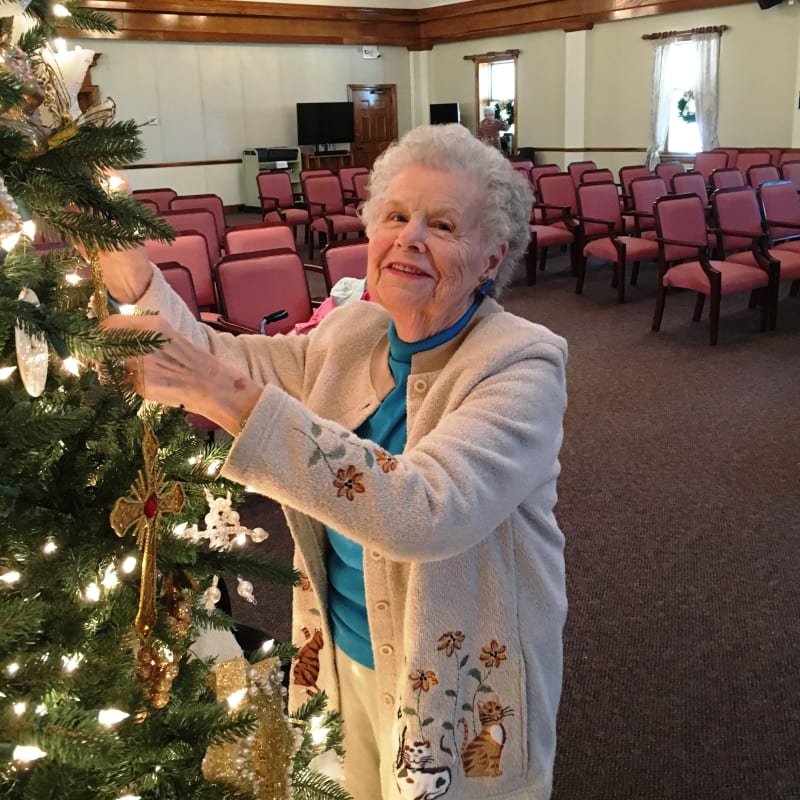 Resident hanging ornaments on a Christmas tree at The Clinton Presbyterian Community in Clinton, South Carolina