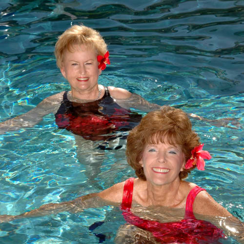 Two residents swimming in the shimmering pool at Mathison Retirement Community in Panama City, Florida. 
