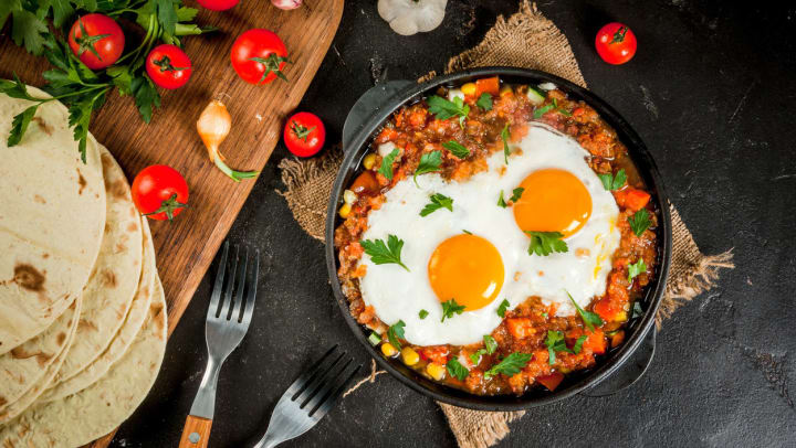 Overhead shot of huevos rancheros in a cast iron dish