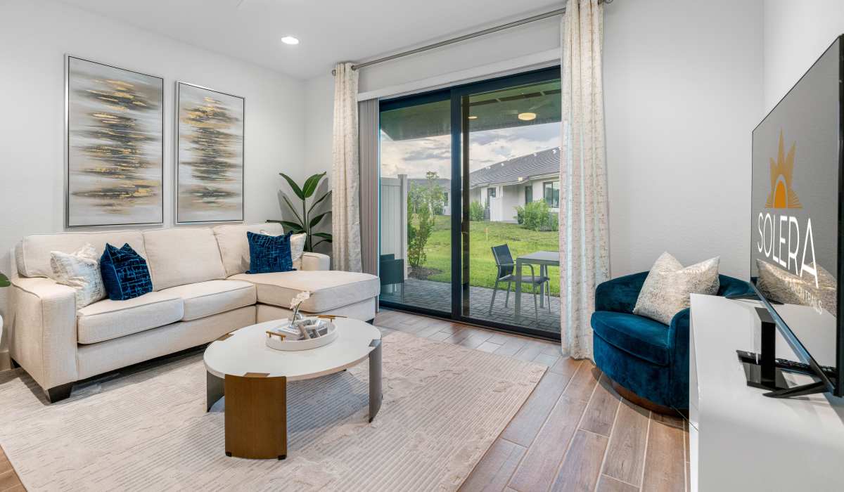Living room with sofa and sliding glass door at Solera at Avalon Trails in Delray Beach, Florida