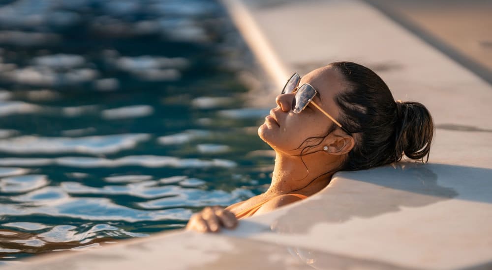 Resident relaxing in the resort-style swimming pool at Iron Horse Apartments in Stockton, California
