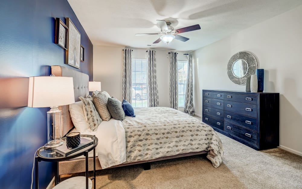 Model bedroom with a ceiling fan and great natural light at The Woods at Polaris Parkway Apartments & Townhomes in Westerville, Ohio