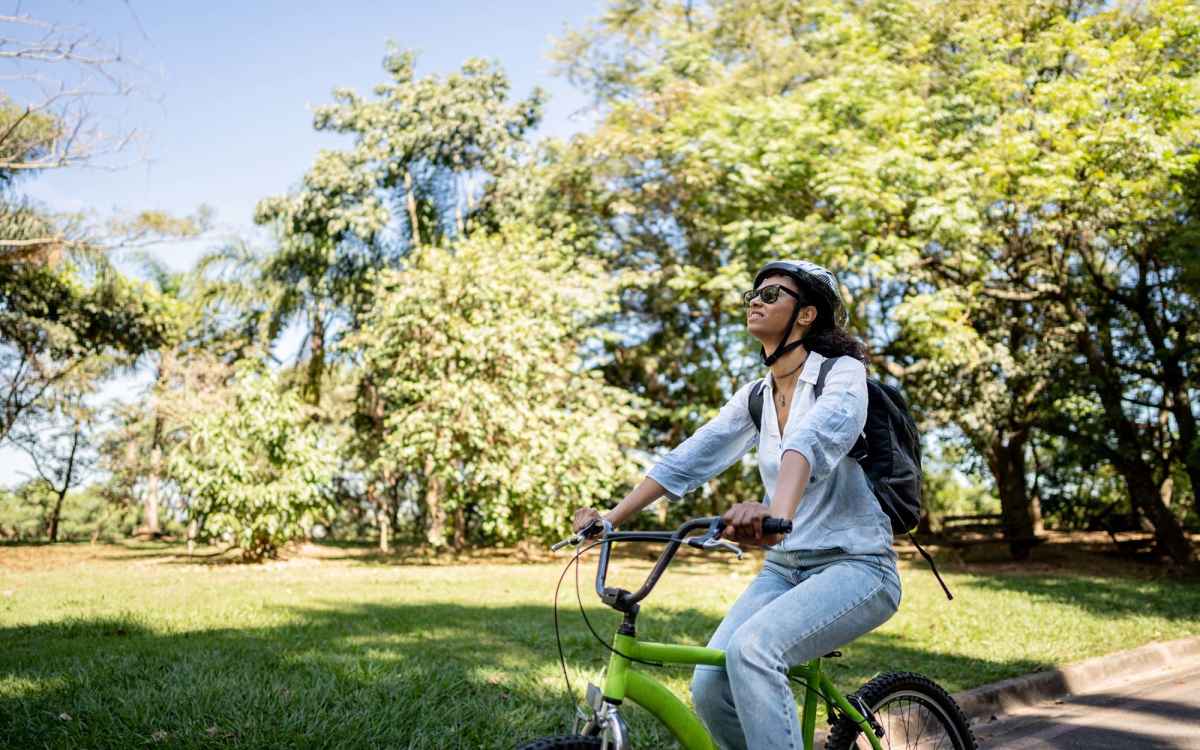 Resident riding a bicycle in a park near Highland Bay Apartments in Rochester, New York