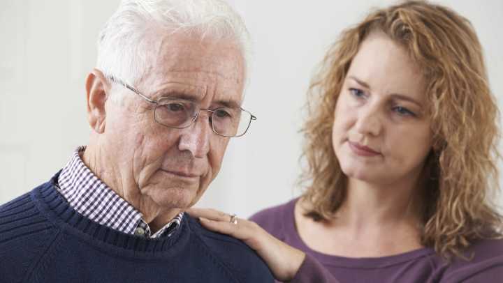 Confused senior adult man with adult daughter looking concerned