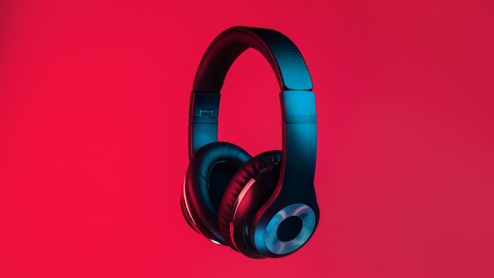 Pair of black headphones on red background