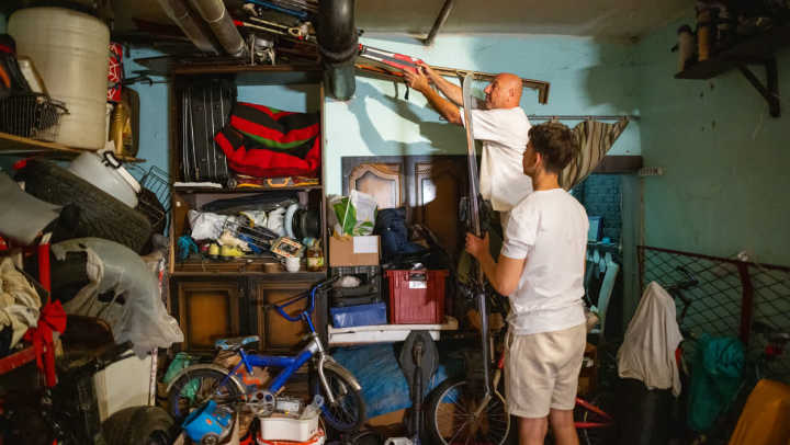 A father and son clearing sports gear out of their garage.