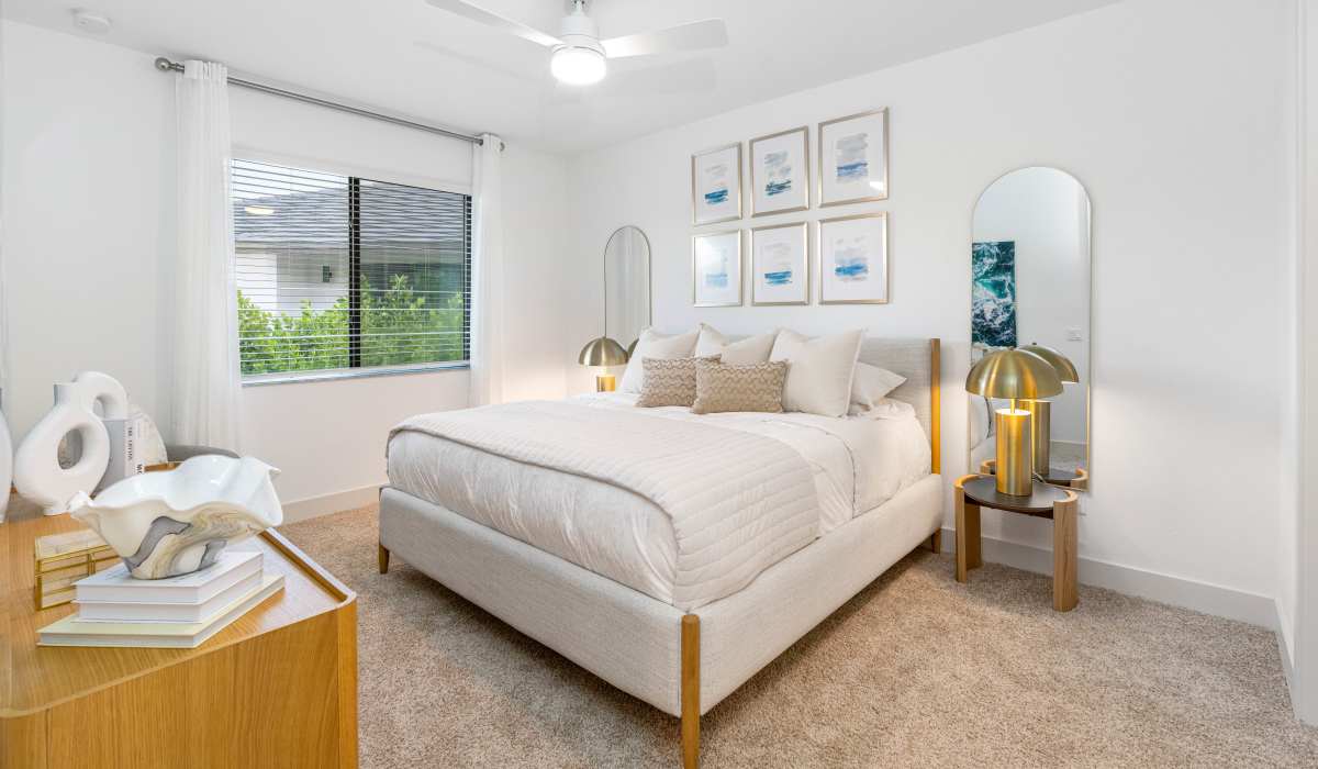 Bed with decorative pillows and artwork above at Solera at Avalon Trails in Delray Beach, Florida