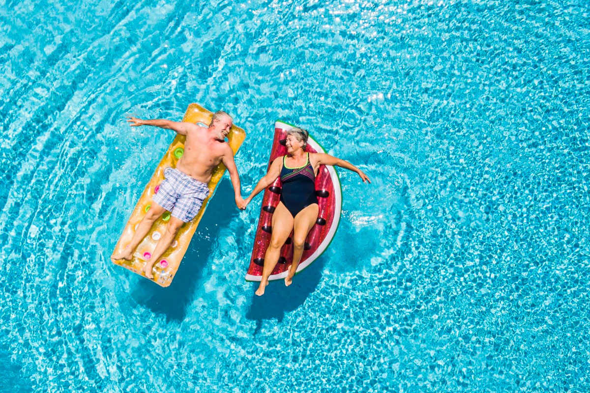 Senior couple enjoying a swim in the swimming pool at Antioch Family & Senior Apartments in Antioch, California