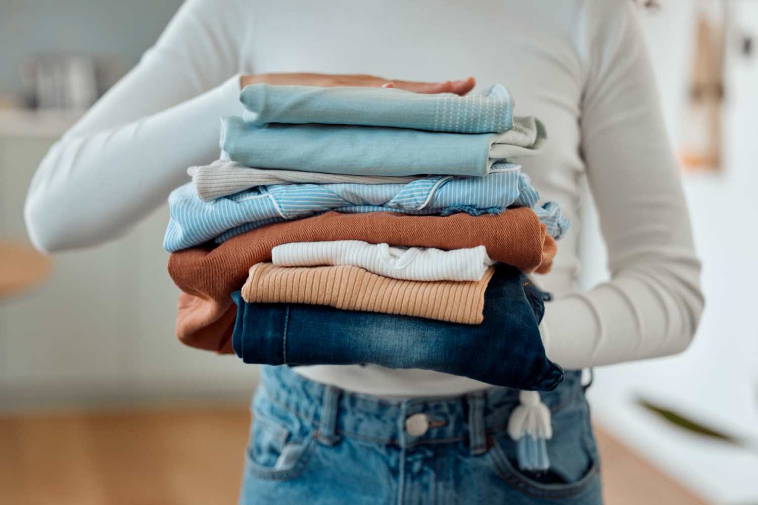 Resident carrying folded clothes in her apartment at Niner Woods in Charlotte, North Carolina