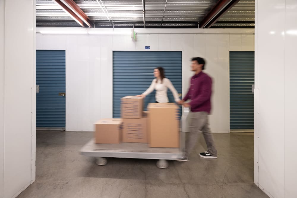 A young couple moving boxes into Hayward Storage LLC in Hayward, California