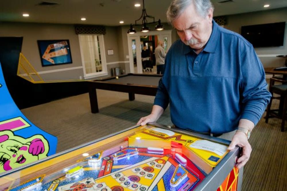 A resident playing pinball at Crescent Fields at Huntingdon Valley in Huntingdon Valley, Pennsylvania