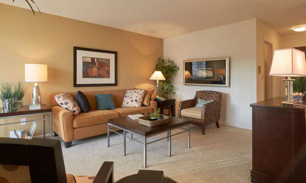 Furnished model living room with sliding glass doors at Muirwood in Farmington Hills, Michigan
