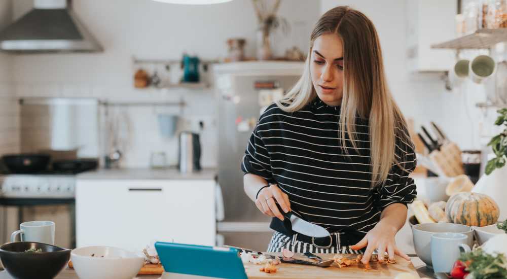 Woman cooking in a kitchen with energy-efficient appliances at Sycamore Villas in Nashville, Tennessee