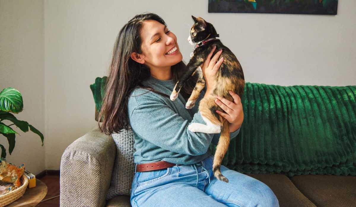 Resident woman with cat in her living room at Arbor Pines Villas in Angleton, Texas