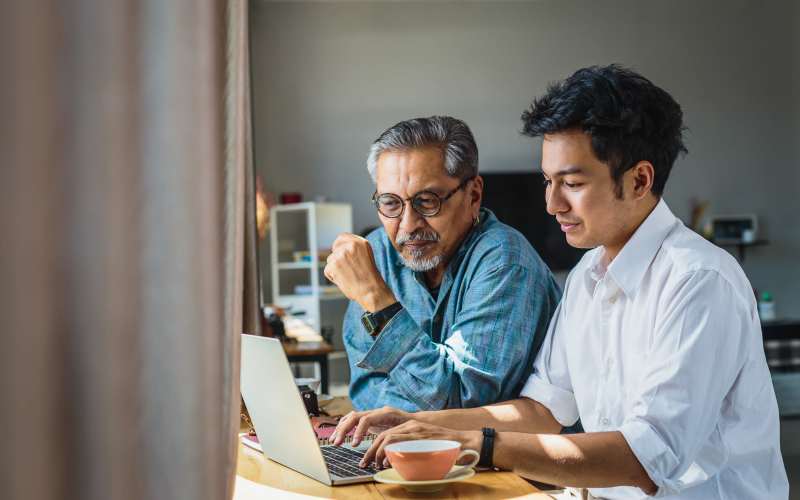 Son and his father using the laptop at Grand Villa of Ocala in Ocala, Florida