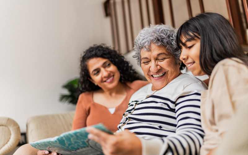 Residents looking through a photo album at Grand Villa of Ocala in Ocala, Florida