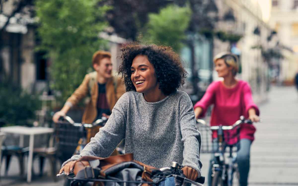 Residents riding bicycle with friends in street near Aventura Residences at The Imperial Club in Aventura, Florida