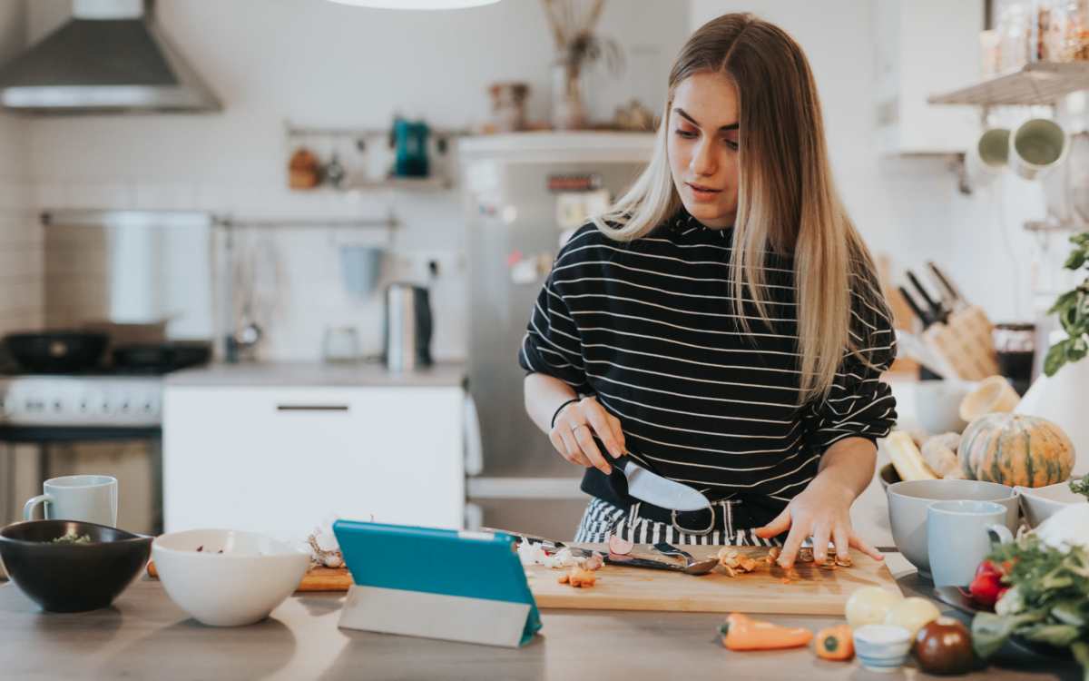 Resident chopping vegetables in her apartment kitchen at Howe in Sacramento, California