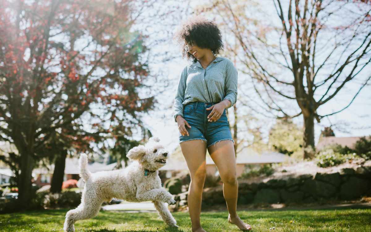 Resident playing their dog through a park near Country Brook Rental Condominiums in San Ramon, California