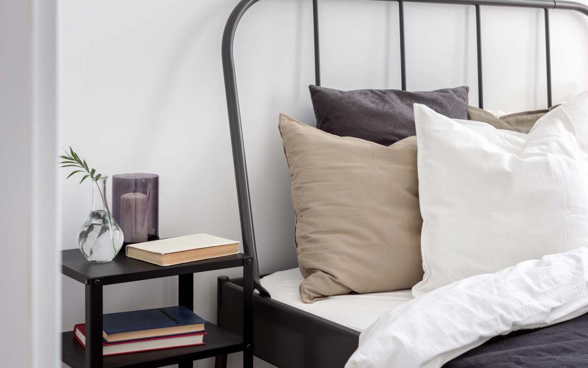 Bedroom with book stand at Lakewood Manor Apartments in Rochester, New York