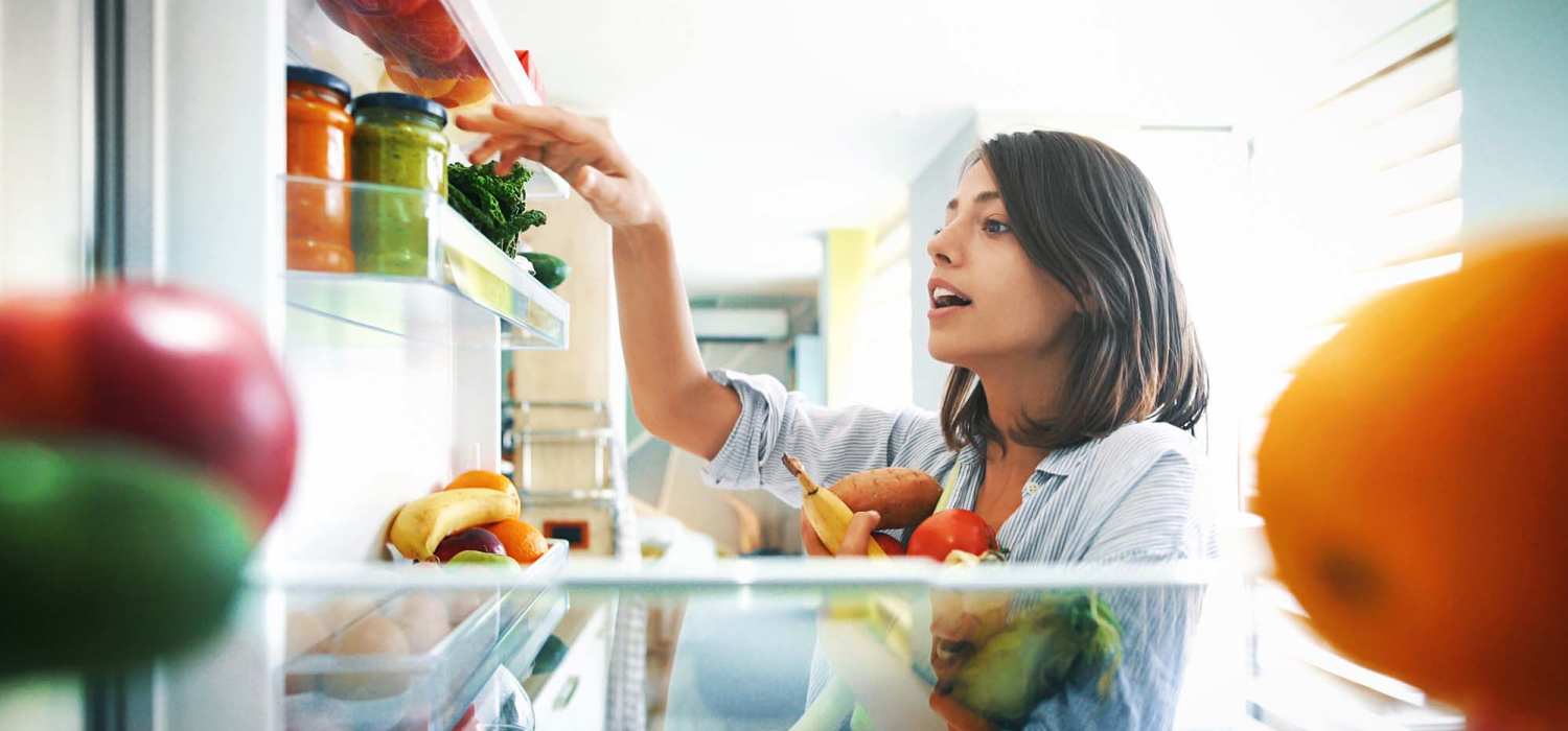 Woman picking something from her refrigerator at Pecan Bend in Mansfield, Texas