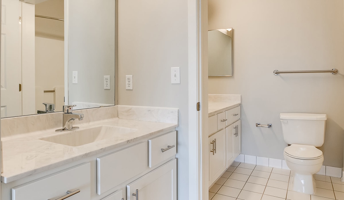 A bathroom with a large vanity mirror at Provence Apartments in Burnsville, Minnesota