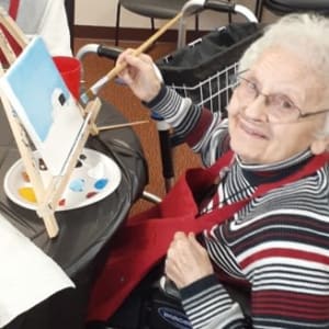 Resident Violet painting a picture at his Dare to Dream event at Milestone Senior Living Woodruff in Woodruff, Wisconsin