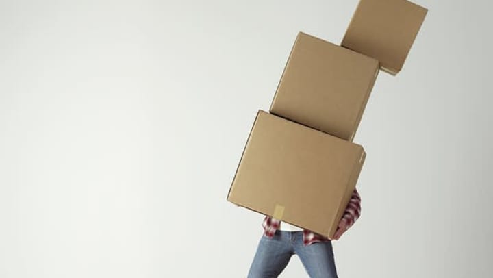Resident carrying storage boxes while moving to new apartment