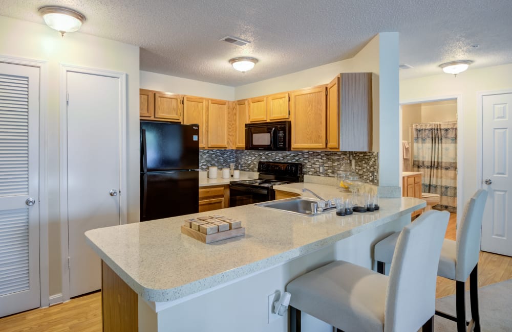 Fully equipped kitchen with a breakfast bar at The Apartments at Diamond Ridge in Baltimore, Maryland