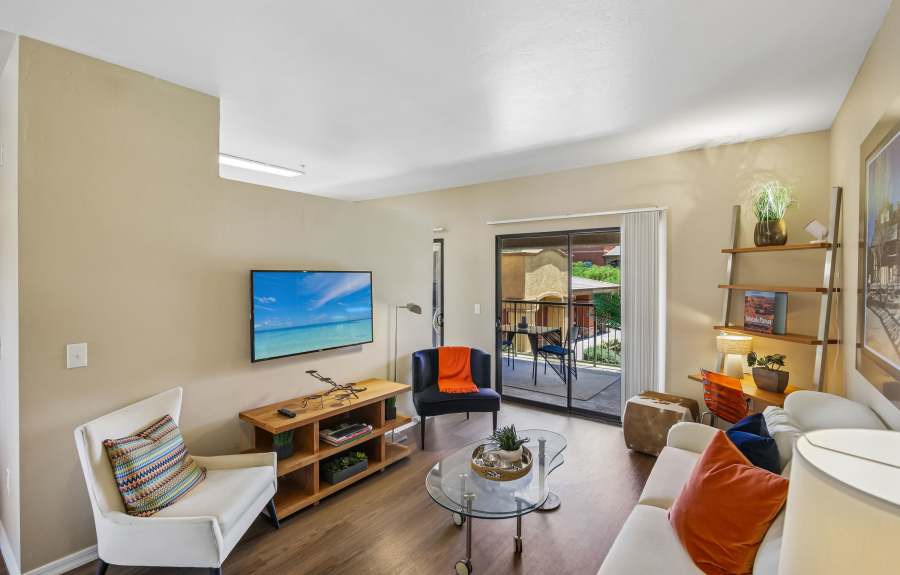 Cozy Apartment Living Room with Balcony Access at Oro Vista Apartments in Oro Valley, Arizona