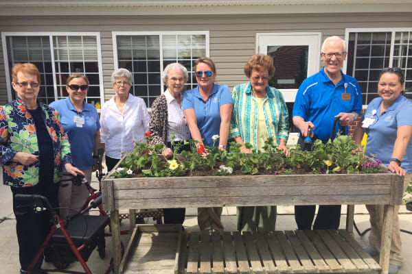 Residents around a flower garden at Trilogy Health Services - Bowling Green in Bowling Green, Ohio