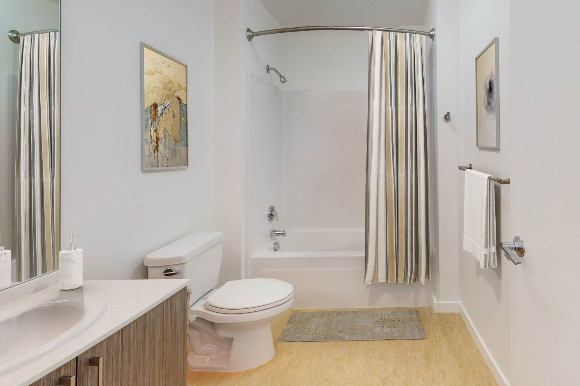 Bathroom with wooden vanity, toilet, sink and shower curtain atThe Union in Portland, Oregon