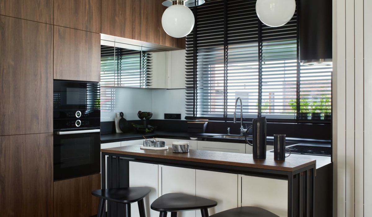 Ultra-modern kitchen with an island, quartz countertops, and custom wood cabinetry in a model apartment at The Fitz Apartments in Dallas, Texas