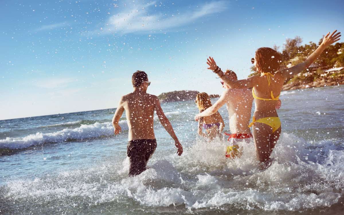 Residents running into the ocean on a beach near City North in Pensacola, Florida