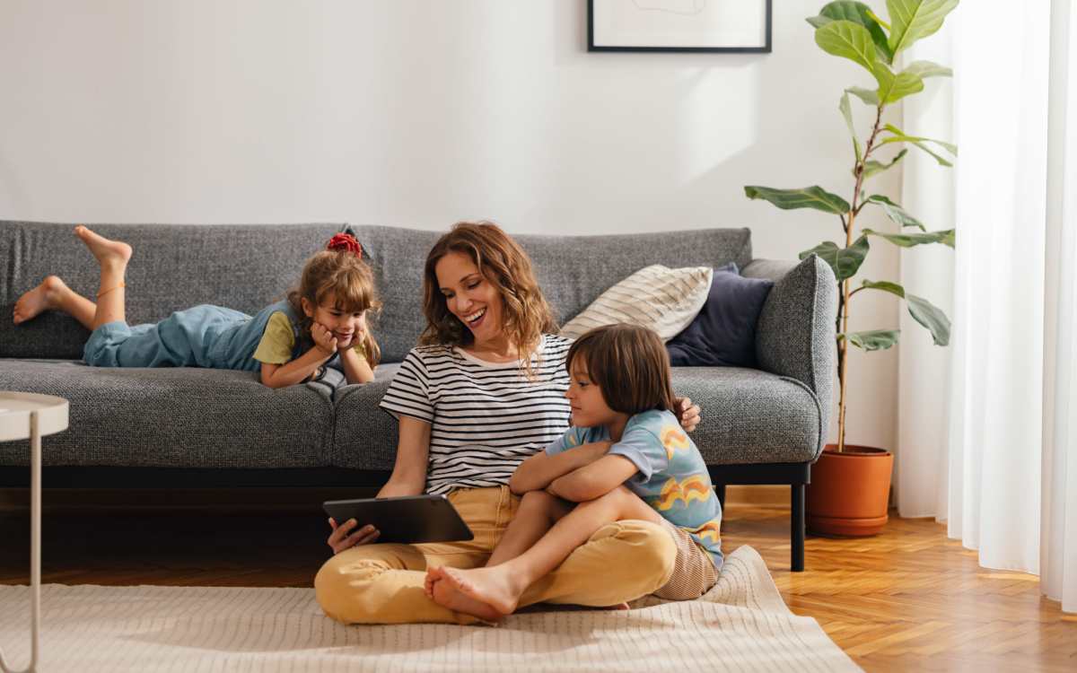 Resident watching with her kids in the living room at Ocean View Living in Norfolk, Virginia