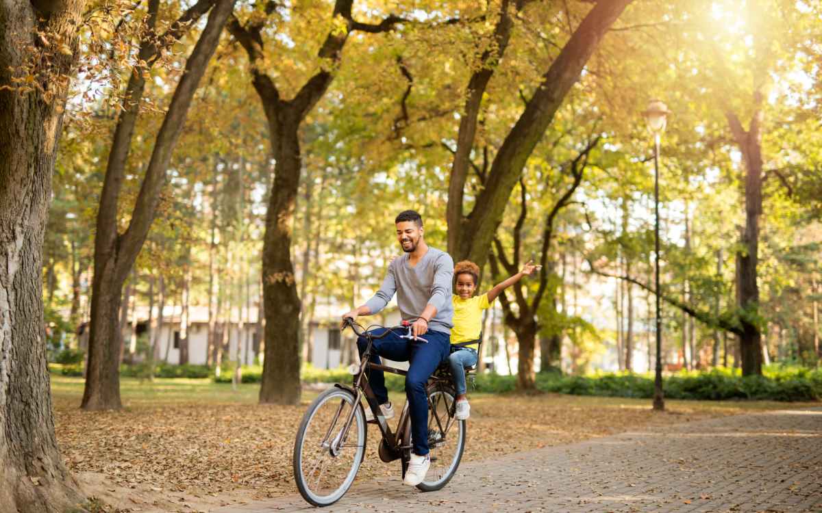Resident riding bicycle in park near Amelia Apartments in Fayetteville, North Carolina