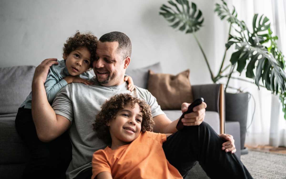 Resident with his kids in living room at Park City Place in Bridgeport, Connecticut
