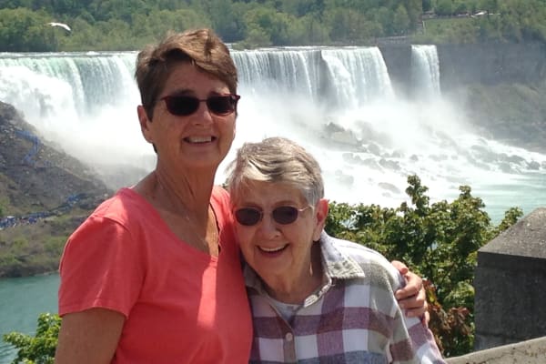Edith and Sue from Alexis Estates Gracious Retirement Living in Allen, Texas, in front of a waterfall