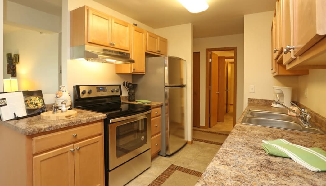  Model kitchen with granite countertops and wooden cabinets at Sun Valley Apartments in Fitchburg, Wisconsin