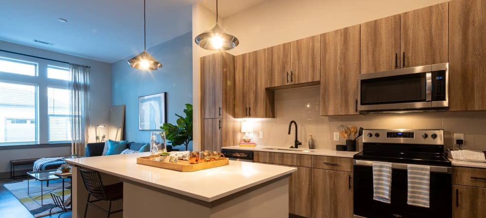 Designer kitchen with a large island and living room with tons of natural light at The Reserve at Patterson Place in Durham, North Carolina