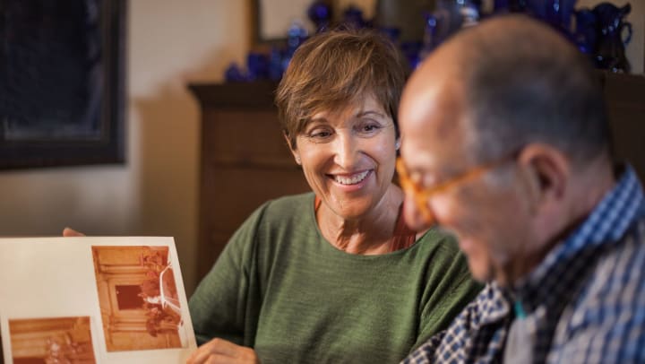 Older adults look at an album of old photographs