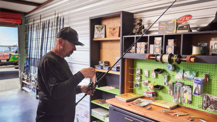 An angler checking out his rod in a fishing shop