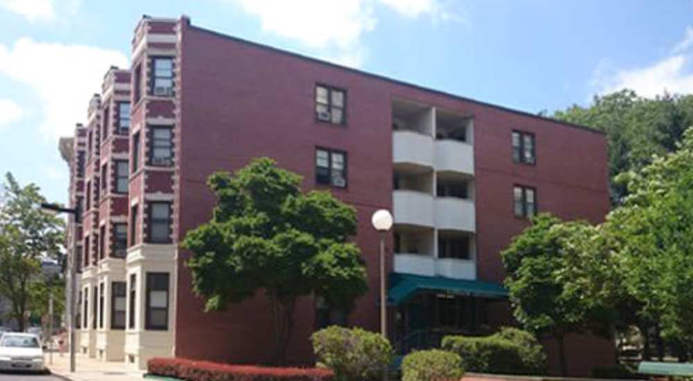 Red brick building with green awning at 71 Westland Apartments in Boston, Massachusetts