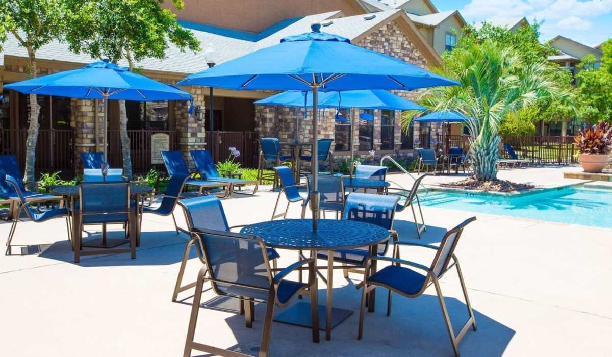 Outdoor seating area by pool at Cobblestone Park in Manvel, Texas